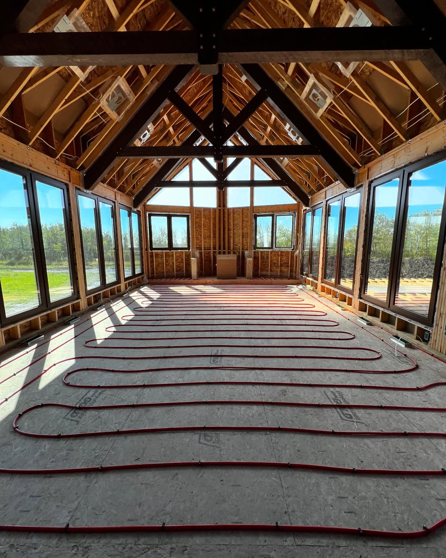 In-floor radiant heating PEX tubing installation by Patterson Mechanical in a custom timber frame home in Manitoba